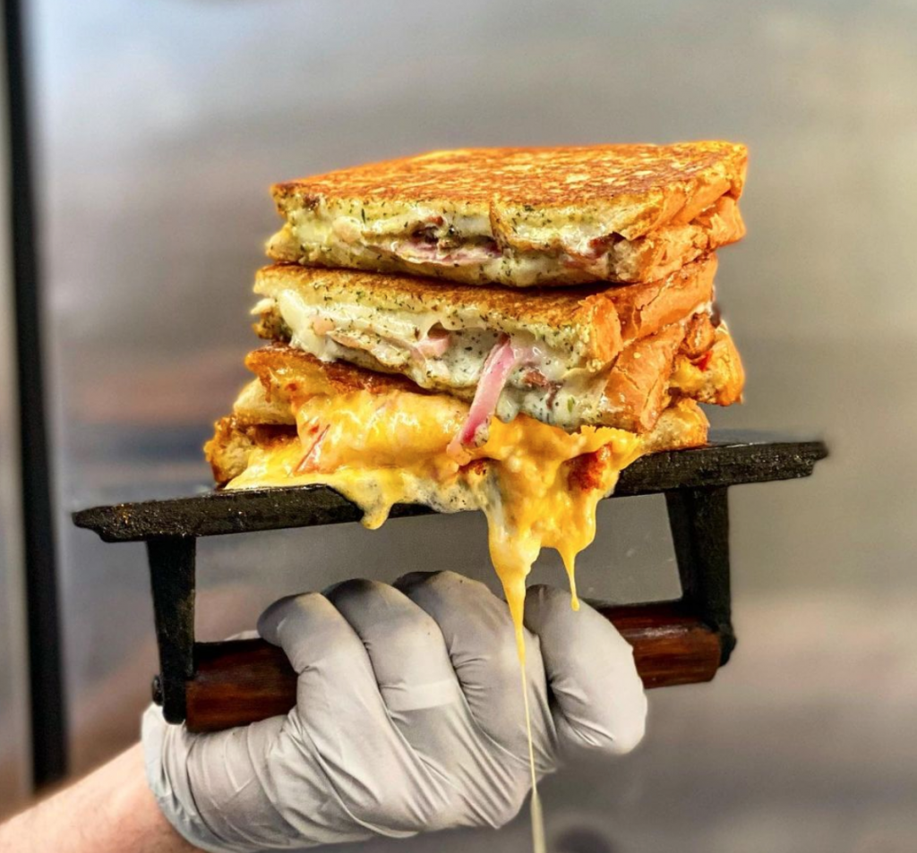 A grilled cheese coming off the griddle at Cheese Smith.